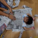 新聞紙をベッドにして、笑顔で遊んでいました。