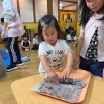 濡れた新聞紙を破れないように慎重に巻いています。