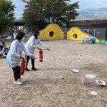 職員が水消火器を使って、初期消火の訓練を受けました。子ども達からは「頑張れ」と声が上がっていました。