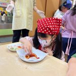 ソースを塗って、丁寧にトッピングをしています。